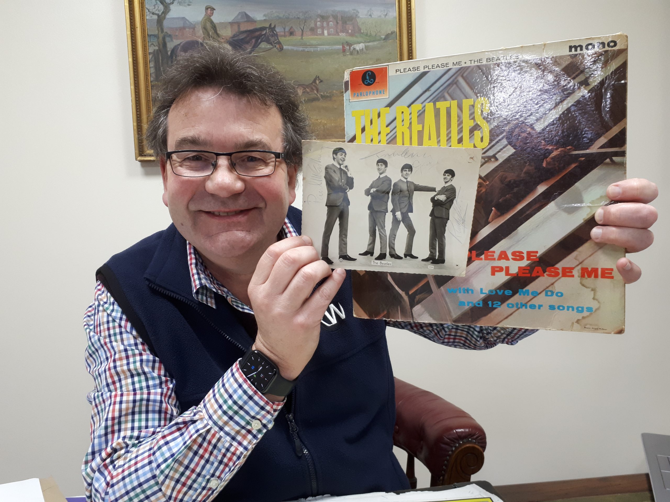 Auctioneer Richard Winterton with the rare autographed photo and a copy of The Beatles’ first LP Please Please Me.